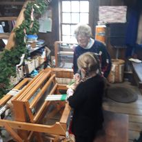 a young visitor weaving